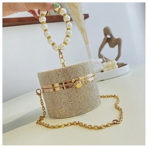 Detail of champagne gold evening clutch with sparkling rhinestones and pearl handle