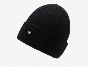 Vue détaillée du bonnet en maille noire montrant la texture côtelée et l'écusson ny
