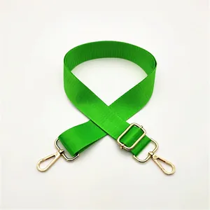 Detail of adjustable vibrant green nylon bag strap with polished gold lobster clasps