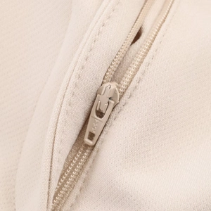Detailed macro view of the premium YKK zipper on beige woven trousers for women