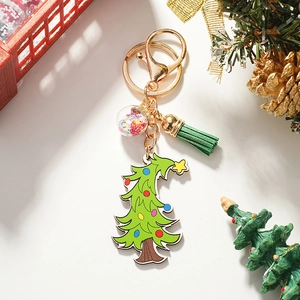 Détail du porte-clés sapin de Noël avec boule scintillante et pompon en cuir vert foncé