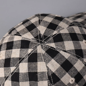 Macro shot of high-quality linen plaid baseball cap showing textured fabric and stitching