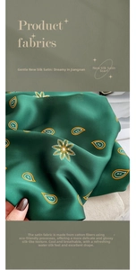 Dettaglio di sciarpa in seta verde scuro con motivi paisley gialli e floreali