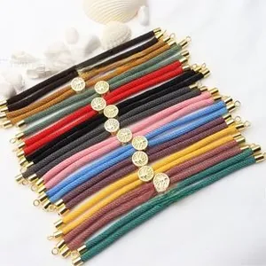 Close-up of colorful braided cords with gold tree of life sliding metal clasps