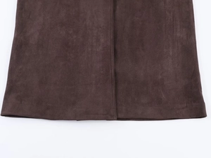Detailed macro view of the brown faux suede fabric and precise stitching on garment hem
