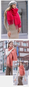 Close-up of soft tassel edges and vibrant rose pink fabric on a cozy cashmere scarf
