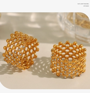Detail of gold-plated honeycomb rings with sparkling crystals in artistic lighting