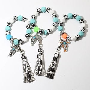 Detailed flat lay of colorful silicone bead bracelets with cow head charms and leather tassels