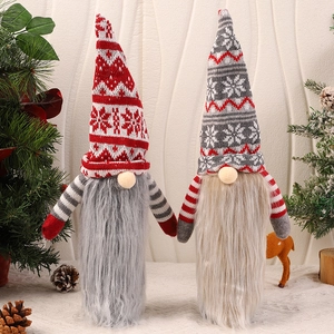 Detail of red and grey knitted Christmas gnome wine bottle covers with snowflake patterns