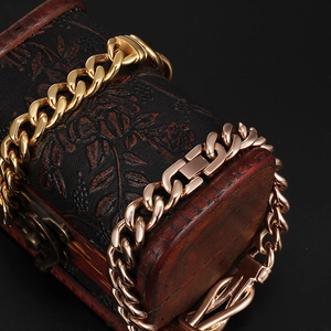 Macro shot of gold and rose gold Cuban link bracelets showing thick metallic texture