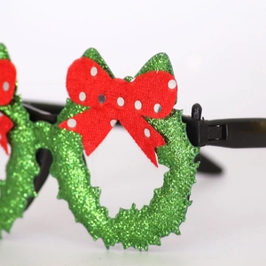 Close-up of Christmas wreath glasses with green glitter finish and red polka dot bow