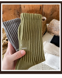 Close-up of thick rib-knit cotton socks with YOURSELF print in olive and grey
