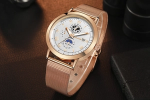 Detail of rose gold mesh strap watch with white moon phase dial and Roman numerals