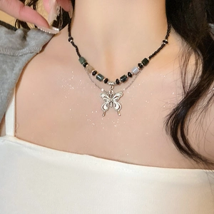 Detail showing beaded black woven necklace with a vintage silver hollow butterfly pendant