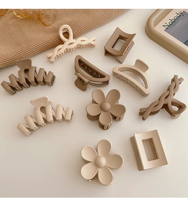 Flat lay of matte milk tea colored claw clips in various shapes like flowers and rectangles