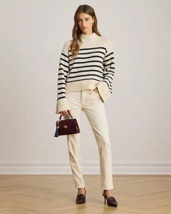 Close-up of a striped high-neck sweater paired with a luxury brown handbag and white trousers