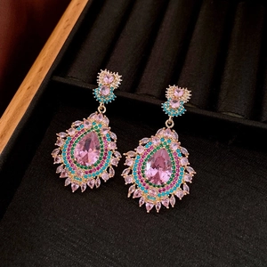 Macro detail of teardrop tassel earrings with pink gems and colorful crystals
