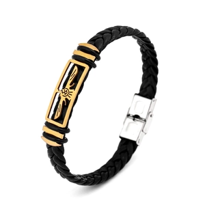 Detail of leather woven bracelet with gold wing-engraved plate and silver metal buckle