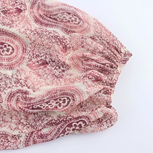 Detail of elastic cuffs on a paisley print dress with cream and burgundy patterns