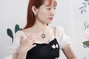 Close-up of elegant silver heart necklace and semi-circle earrings with rhinestones