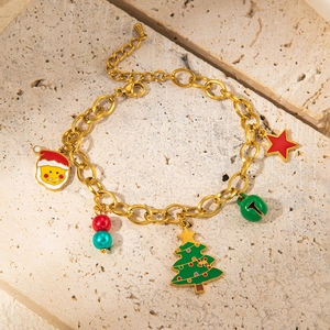 Detail of Christmas gold chain bracelet with Santa Claus and festive colorful charms