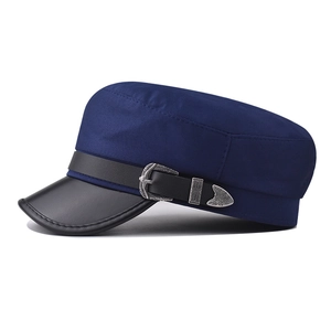 Detail of navy military cap with black leather brim and vintage silver metal buckle accent