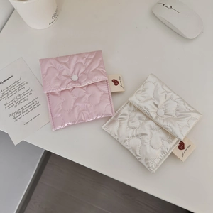 Detail of pink and white heart-quilted sanitary pouches with a woven label accent