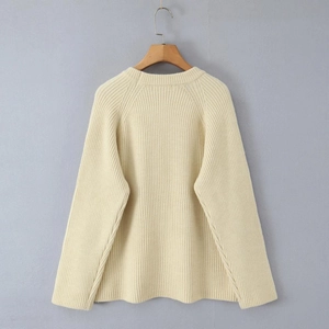 Detailed knit texture of cream-colored crewneck sweater with vertical ribbed patterns
