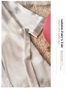 Detail of luxurious champagne satin bathrobe fabric texture with silk sheen and tie edge
