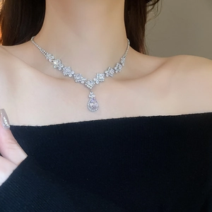 Close-up of elegant teardrop zircon pendant necklace on model with black outfit