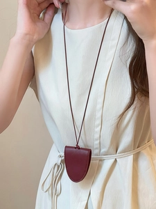 Detail of dark red faux leather magnetic glasses holder necklace worn on a model