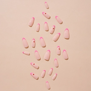 Pink French almond press-on nails with red heart patterns on a beige background