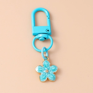 Detailed view of a blue enamel flower keychain with golden metal edges and spring hook