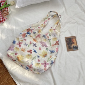 Detailed view of the mesh floral tote bag with vibrant tulip and daisy patterns on a white base