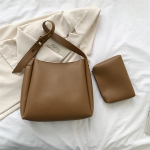 Detail of brown leather tote bag with matching pouch and silver metal buckle accents