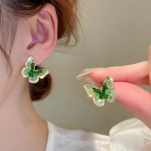 Détail des boucles d'oreilles papillon vertes avec incrustations de zircone brillant