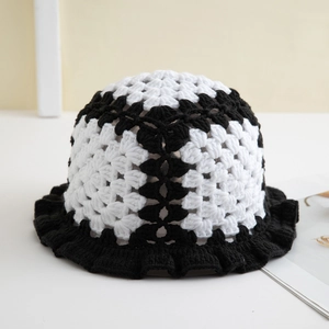 Detail of handmade crochet bucket hat with black and white knit floral patterns