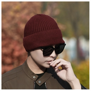 Close-up of burgundy thick ribbed knit beanie for men with autumn outdoor background