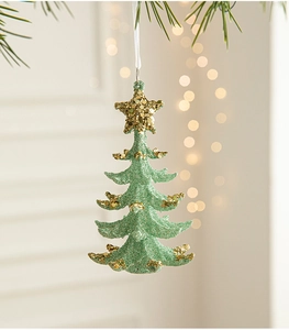 Detailed view of mint green glitter Christmas tree ornament hanging on pine needles