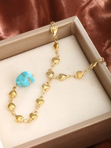 Detailed shot of 14K gold plated heart chain necklace with turquoise in a gift box