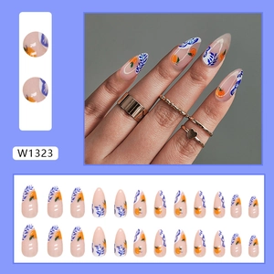 Almond-shaped press-on nails with hand-painted orange fruit and blue leaf designs