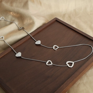 Double-layered silver heart long necklace with zirconia accents on luxury gold satin