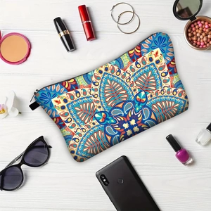 Mandala print makeup bag on white wood background with fashion travel accessories