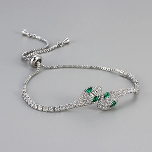 Luxurious silver snake head bolo bracelet with sparkling white diamonds and green eyes