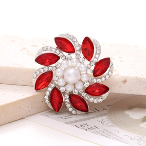 Detalle de adorno para zapatos en plata con cristales rojos y perlas blancas de imitación