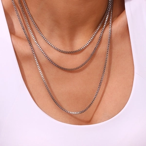 Macro shot of silver Venetian box chains layered on model to show texture and structure