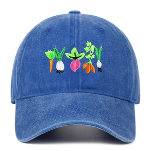 Close-up of vibrant vegetable embroidery on washed blue cotton denim baseball cap