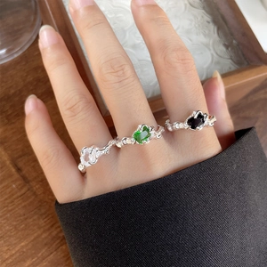 Detail of 925 silver rings with lava texture and colorful rectangular gemstones