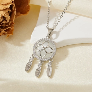 Vue détaillée du pendentif attrape-rêves en argent avec opales blanches et plumes