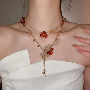 Detailed close-up of layered necklace with acrylic floral charm and golden alloy chain links